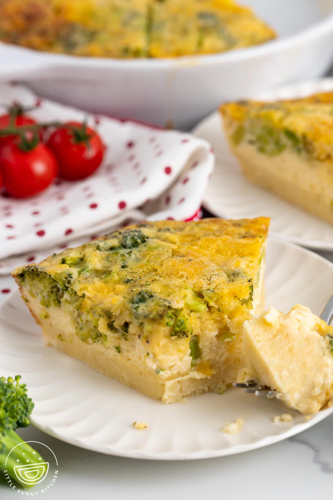 a slice of bisquick quiche. A fork has taken a bite from the pointy end.