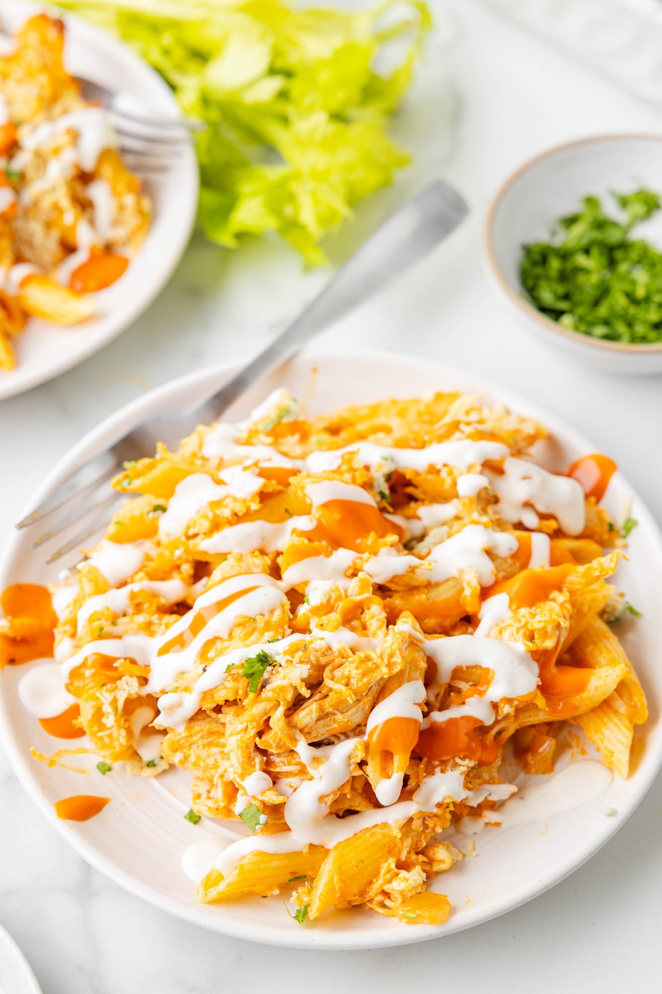 a serving of buffalo chicken casserole on a white plate with a fork.