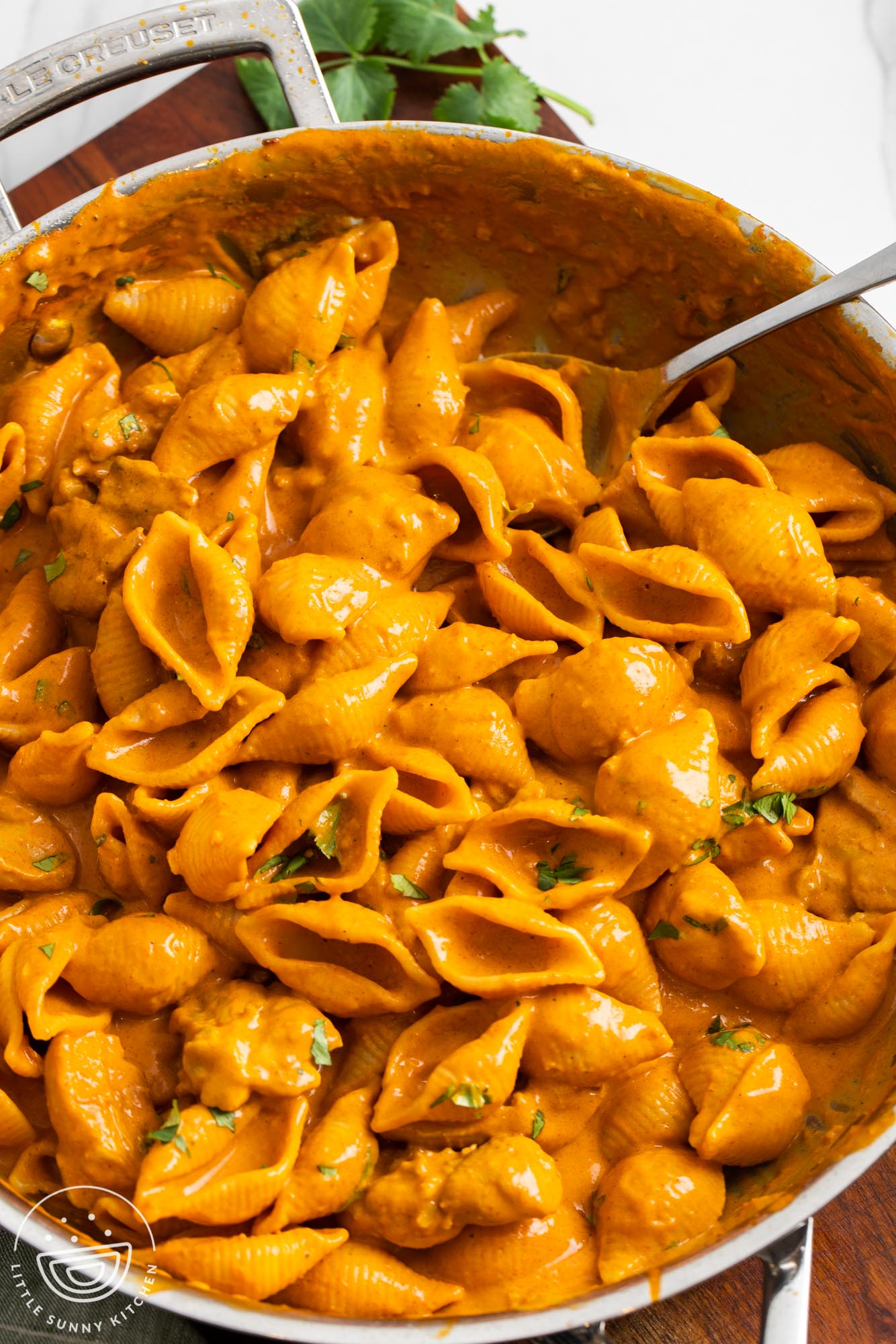creamy pasta with butter chicken in a stainless steel skillet