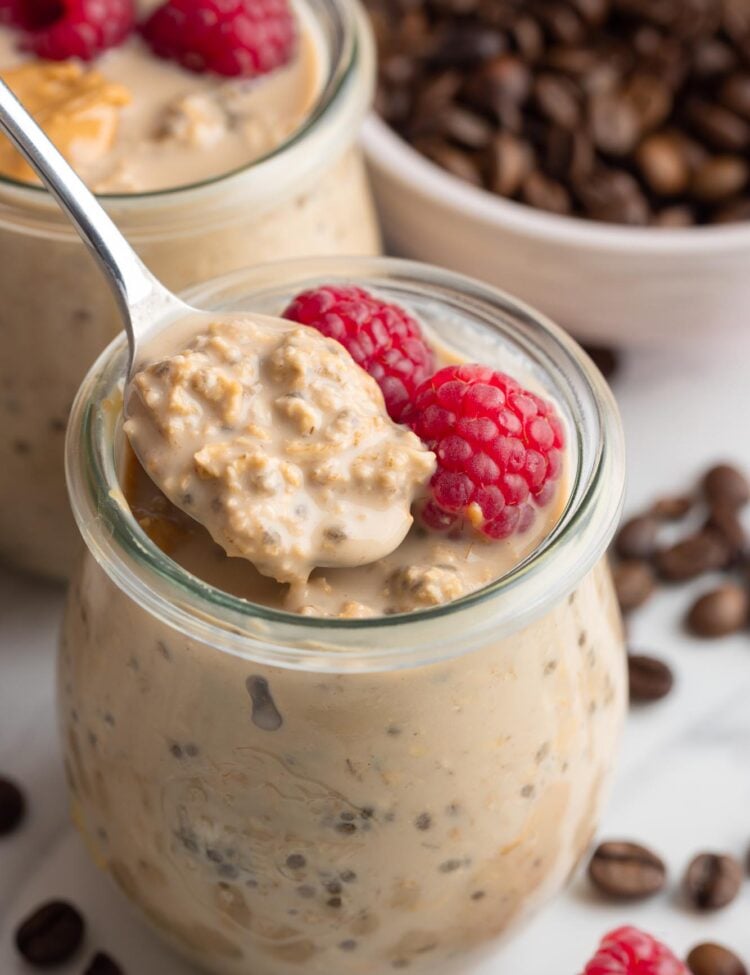 Taking a spoonful of coffee overnight oats from a jar