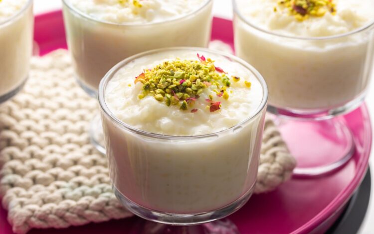 4 glass cups of Lebanese rice puddings, garnished with crushed pistachios