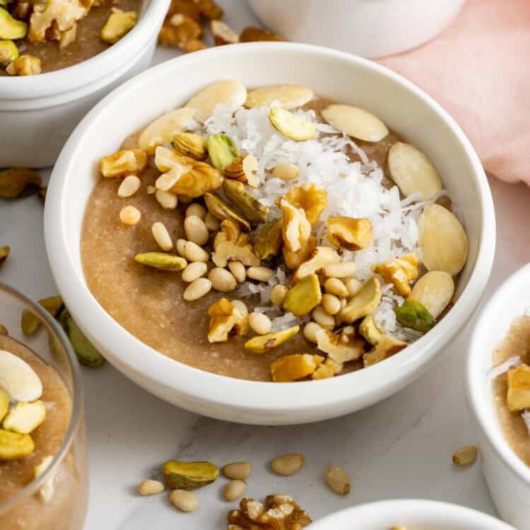 Meghli caraway pudding served in small white bowls, topped with coconut and nuts