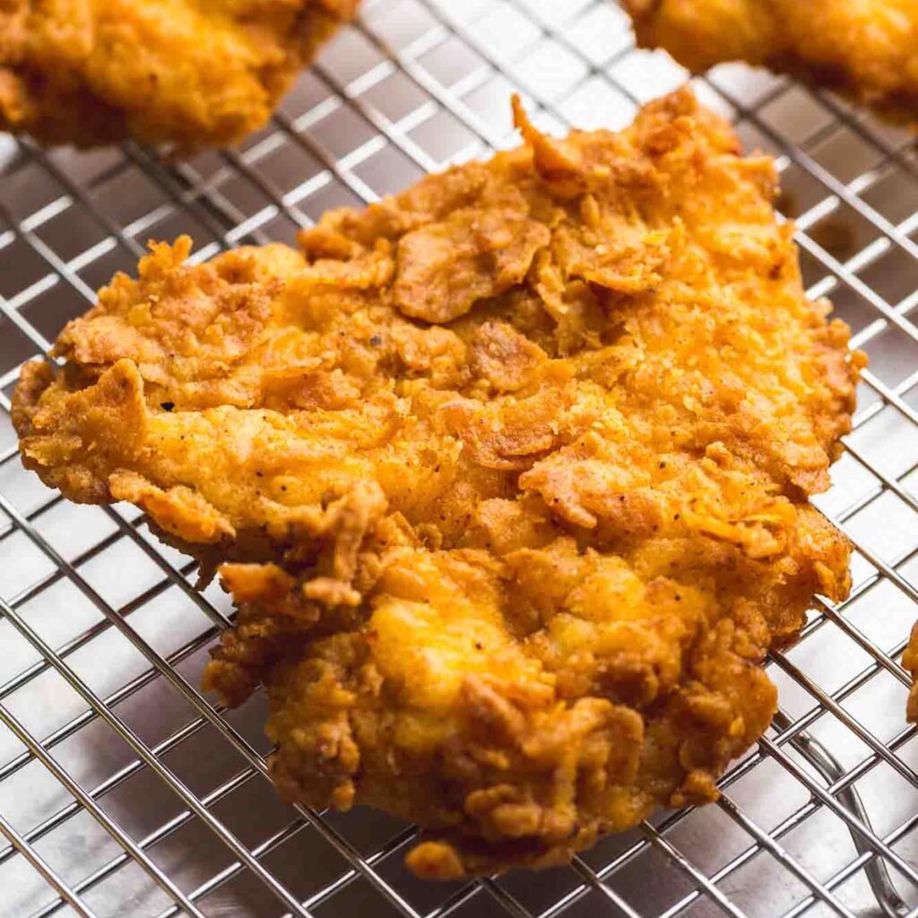 Flaky fried chicken piece placed on a wire rack