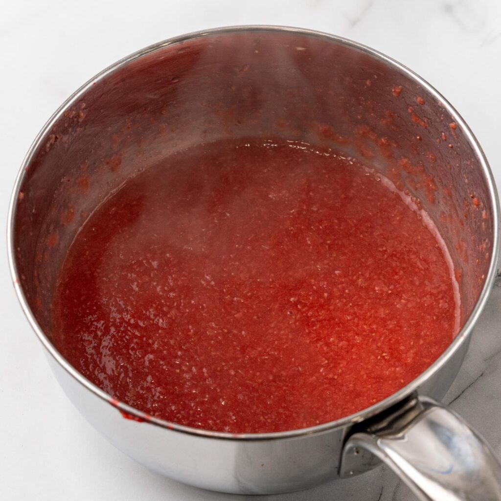 cooked strawberry puree, steaming, in a small saucepan.