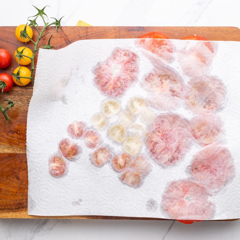 A paper towel used to remove moisture from sliced tomatoes.