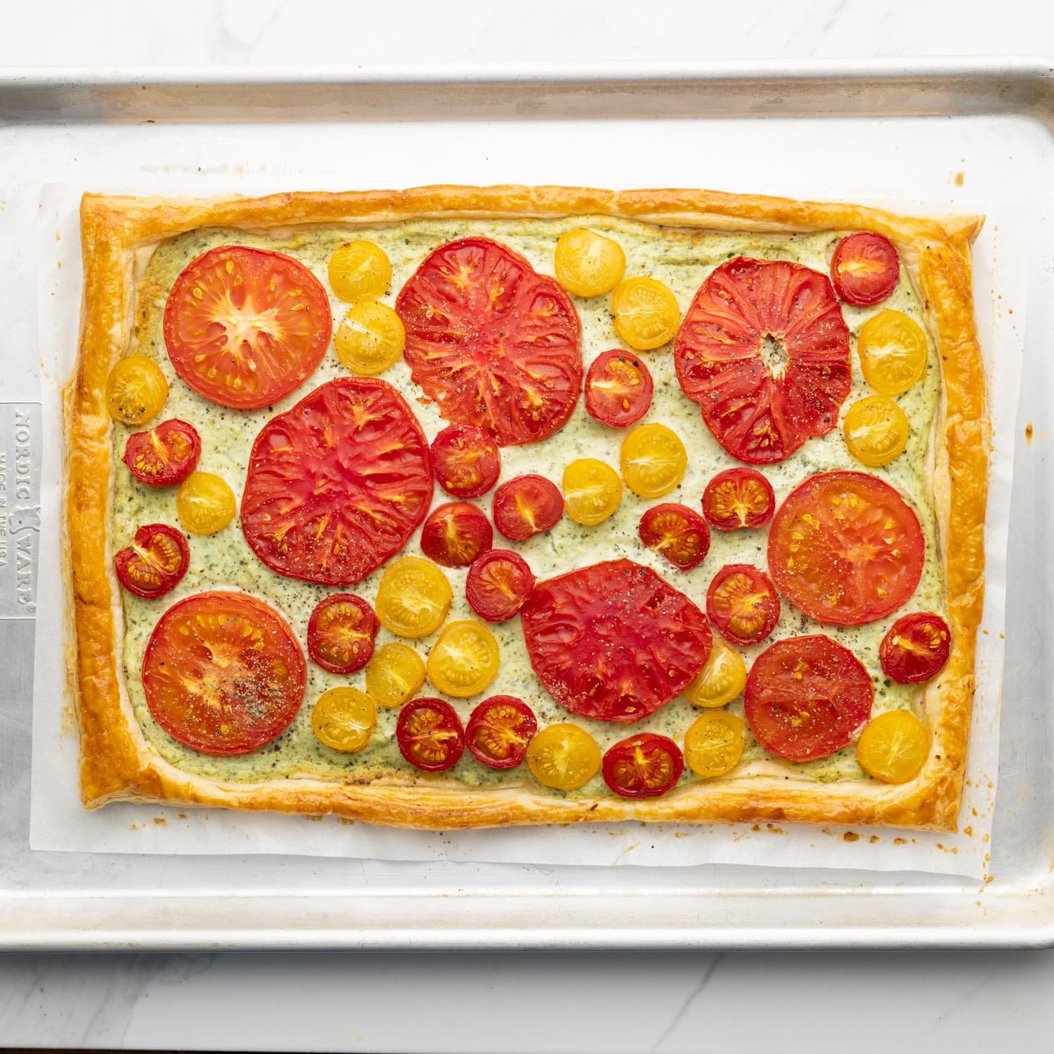 a fresh tomato tart that has been baked on a sheet pan.