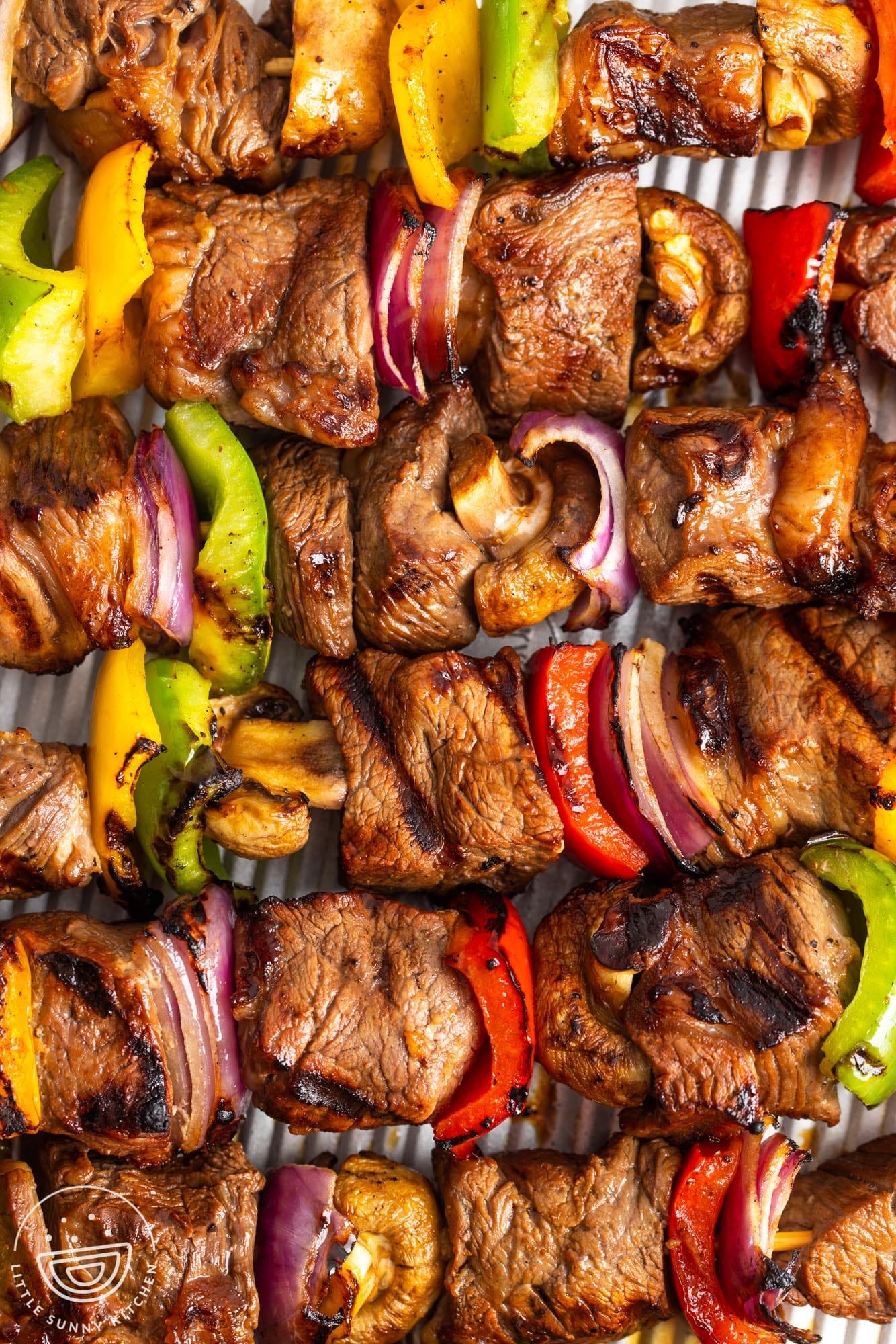 grilled beef kabobs arranged horizontally on a tray.