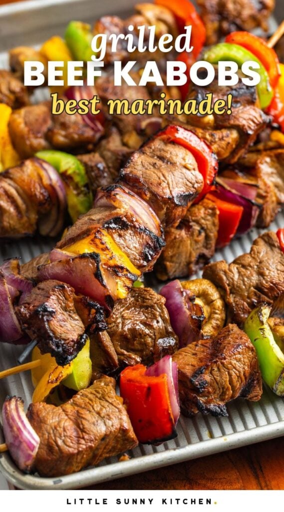 skewers of beef and grilled veggies on a sheet pan. Text overlay says "grilled beef kabobs, best marinade!"