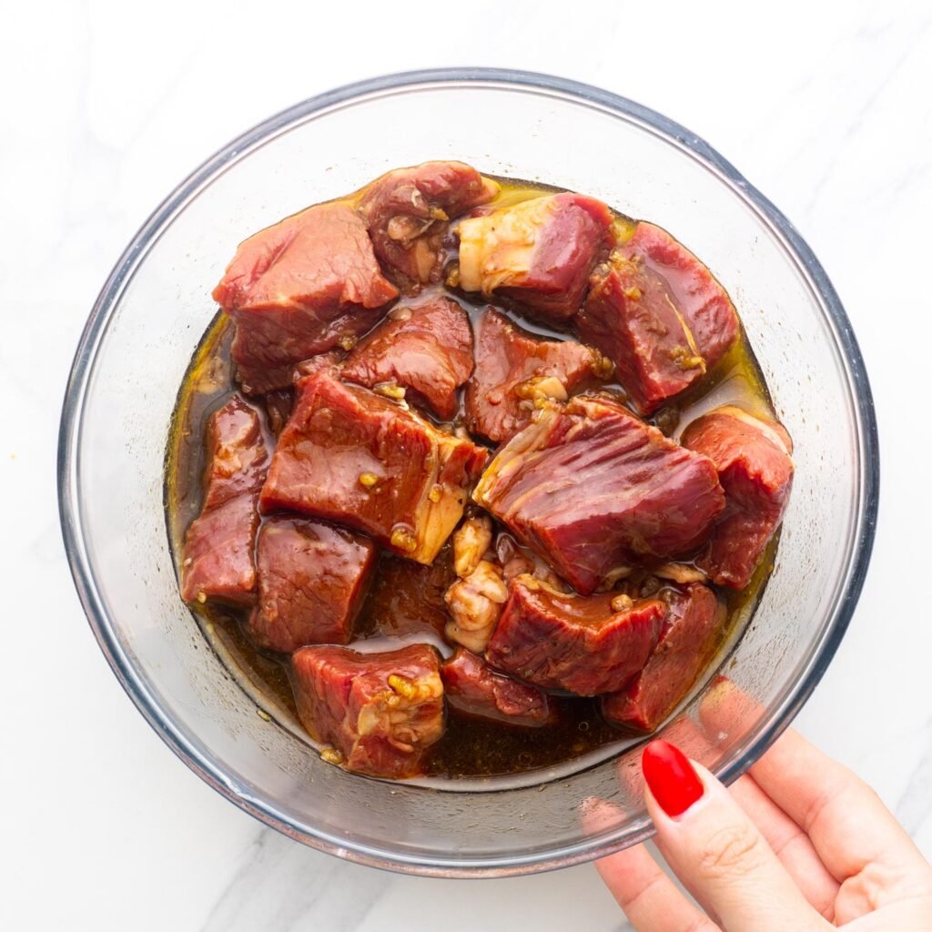 marinated beef for grilled beef kabobs in a glass bowl.