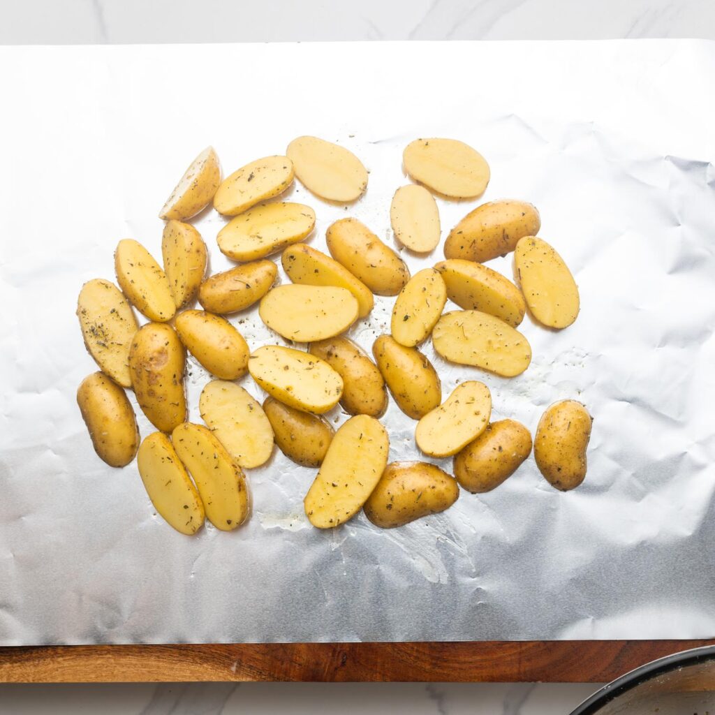 seasoned halved fingering potatoes on a sheet of foil.