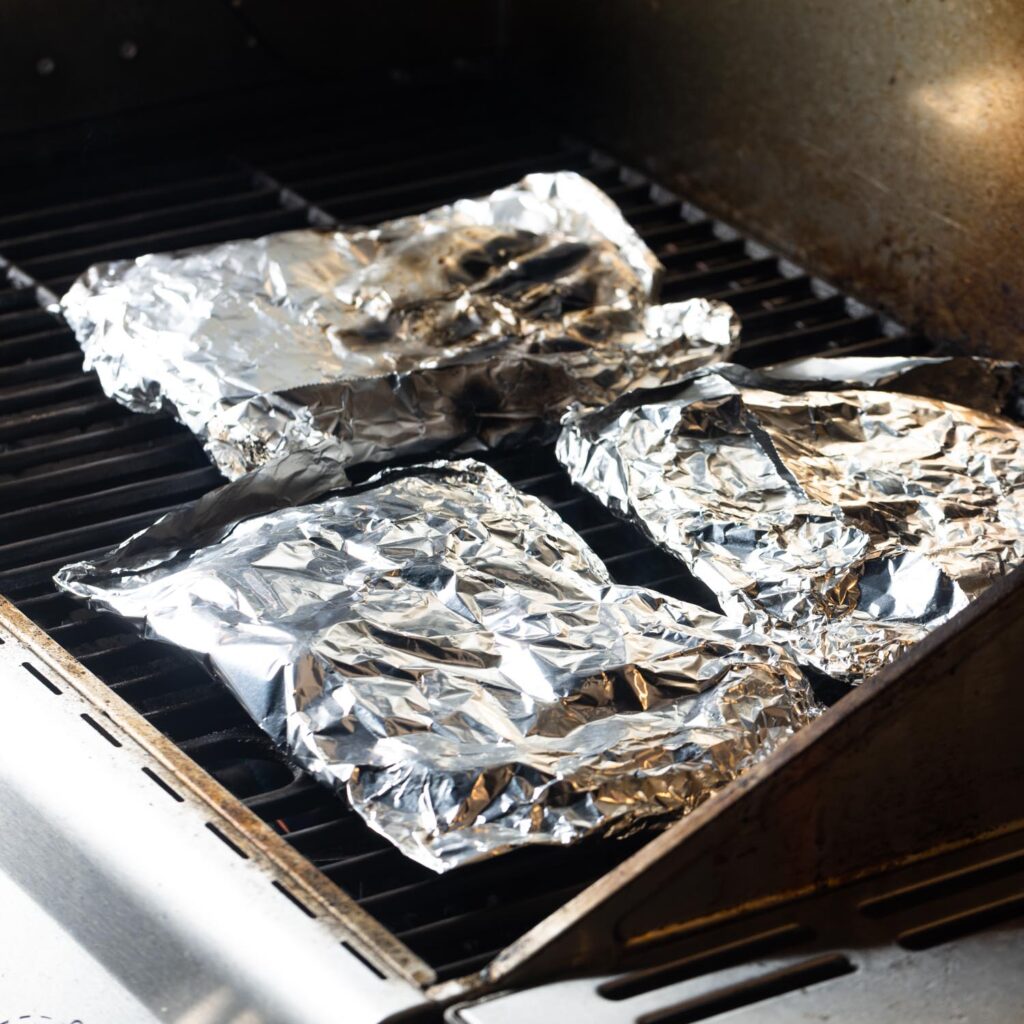 potatoes in foil packets on a grill.