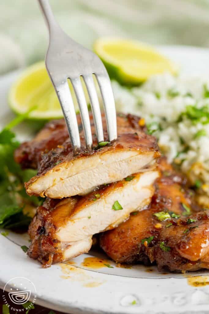 a honey lime chicken thigh cutlet, sliced to show the juicy texture of the meat.