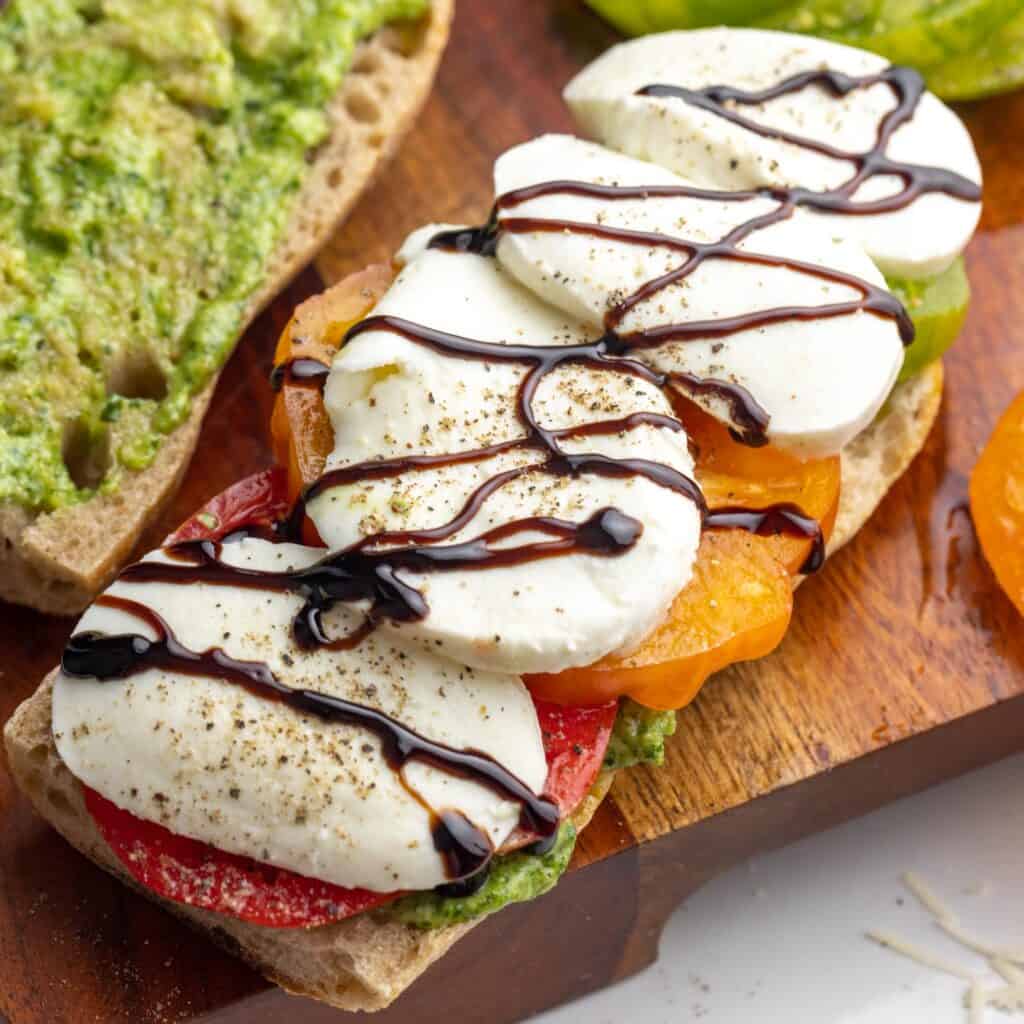 sliced fresh mozzarella on a caprese sandwich, drizzled with balsamic glaze.