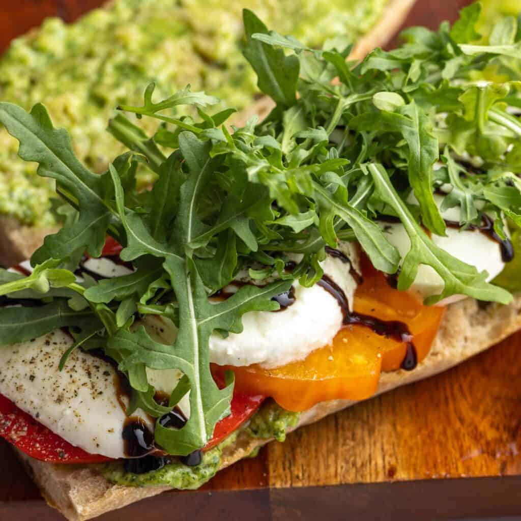 bread layered with tomatoes, balsamic, fresh mozzarella and arugula.