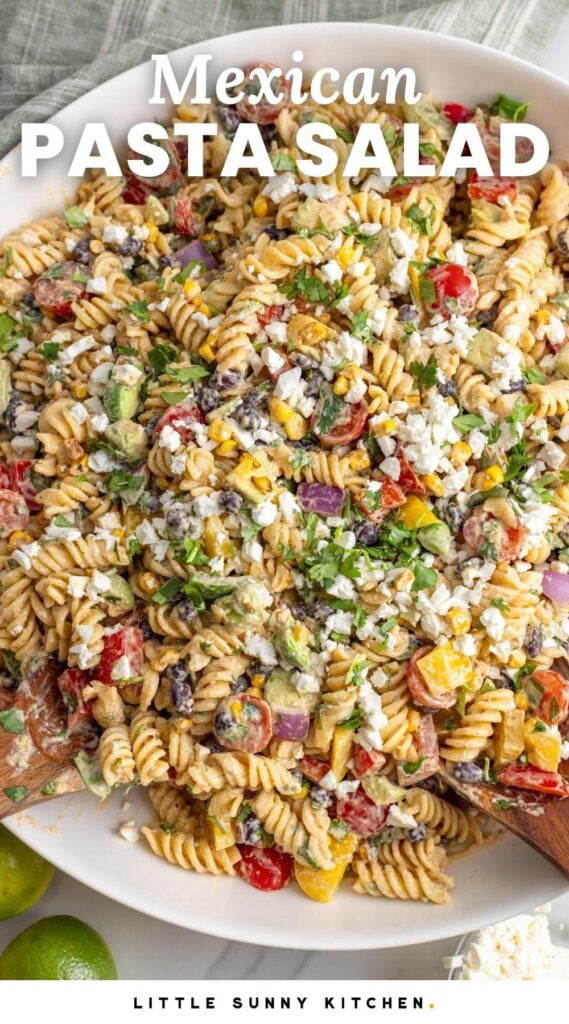 a large white bowl of pasta salad with peppers, cilantro, corn, and cotija cheese. Text overlay says "Mexican Pasta Salad"