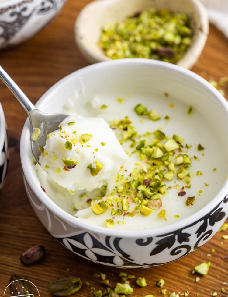 Mouhalabieh served in a small oriental style bowl, with a spoon. Garnished with crushed pistachio