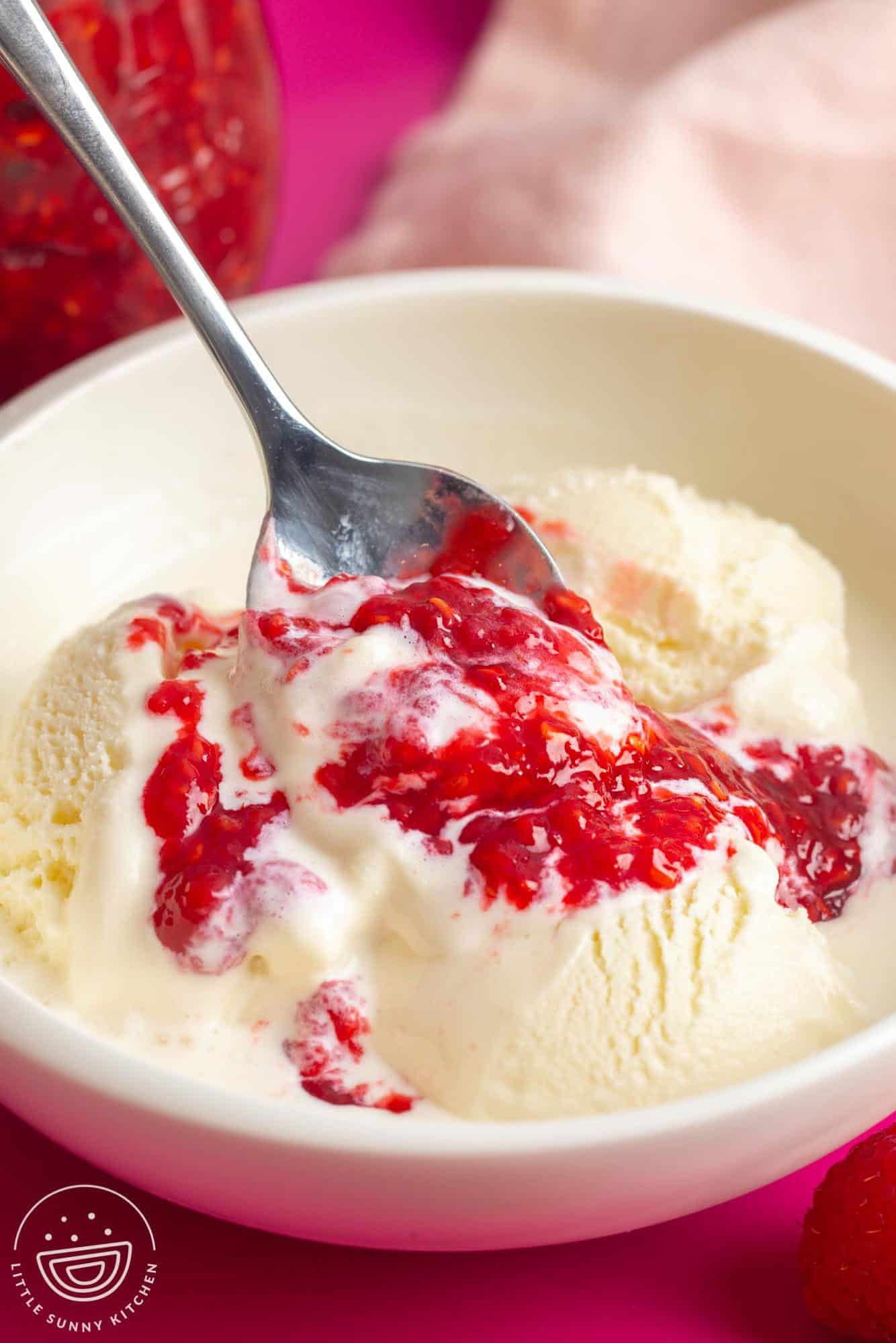 a bowl of vanilla ice cream topped with raspberry compote.