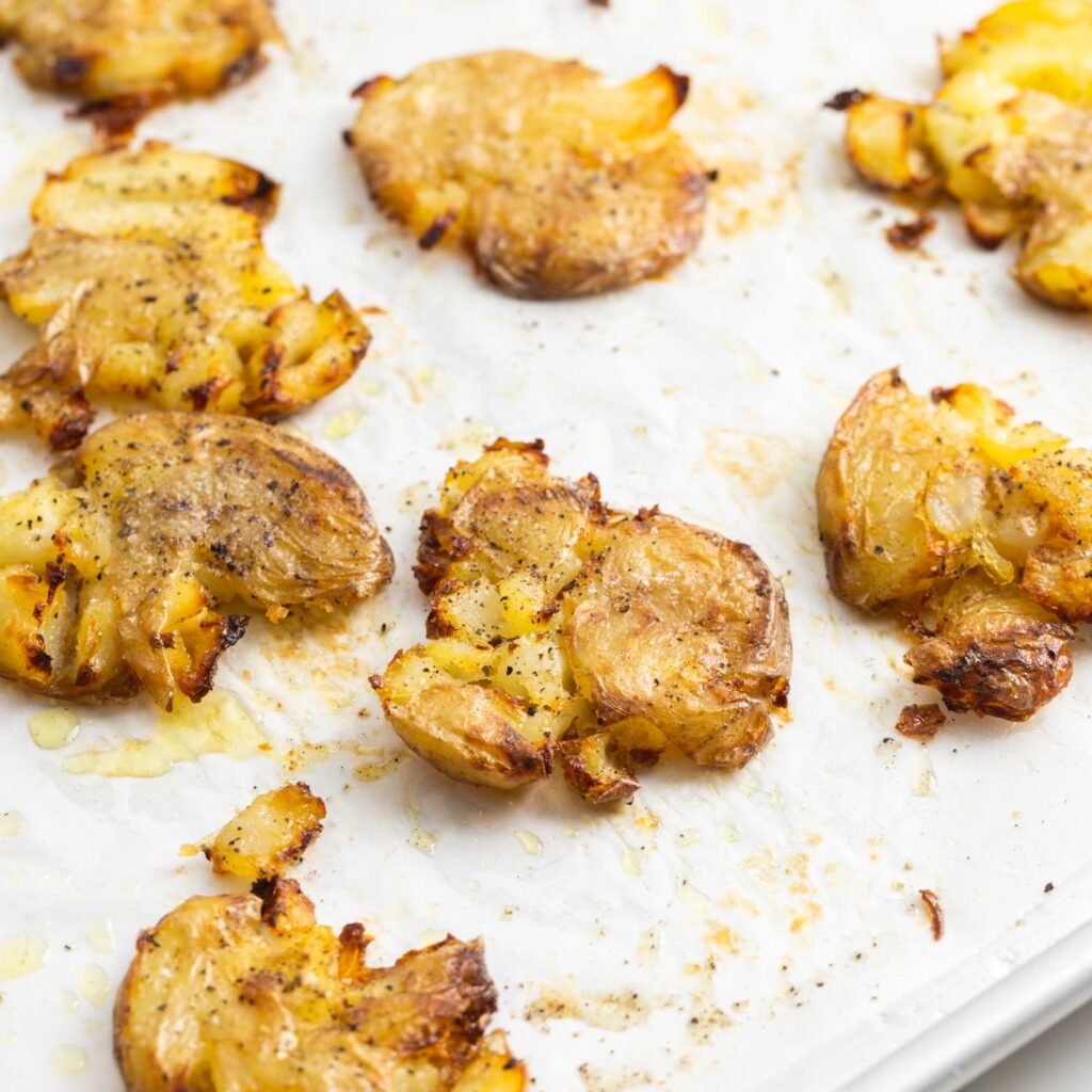 crispy smashed potatoes on a baking sheet lined with parchment paper.