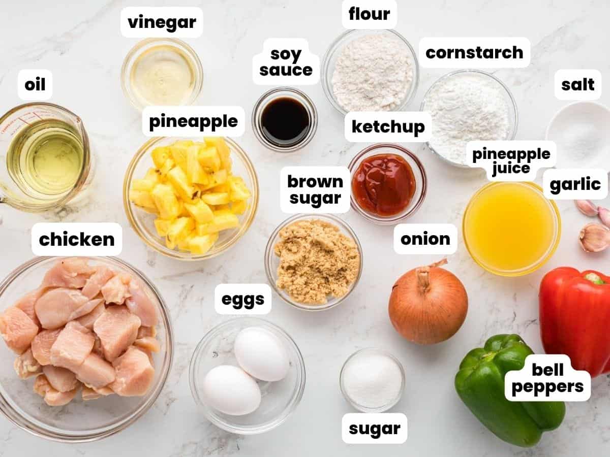 Ingredients needed to make sweet and sour chicken including chicken, pineapple, bell peppers, garlic, eggs, flour, cornstarch, oil, and seasonings