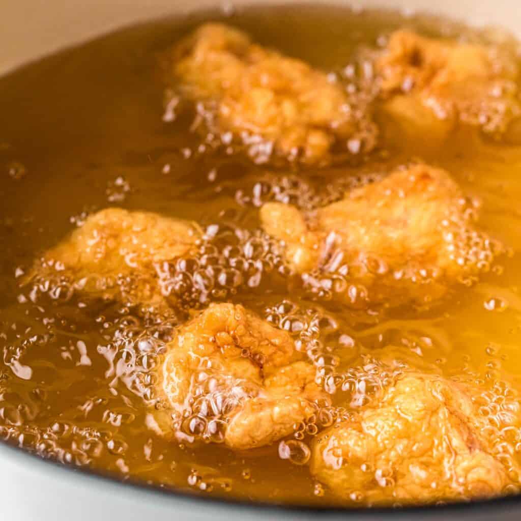 crispy chicken being fried in hot oil