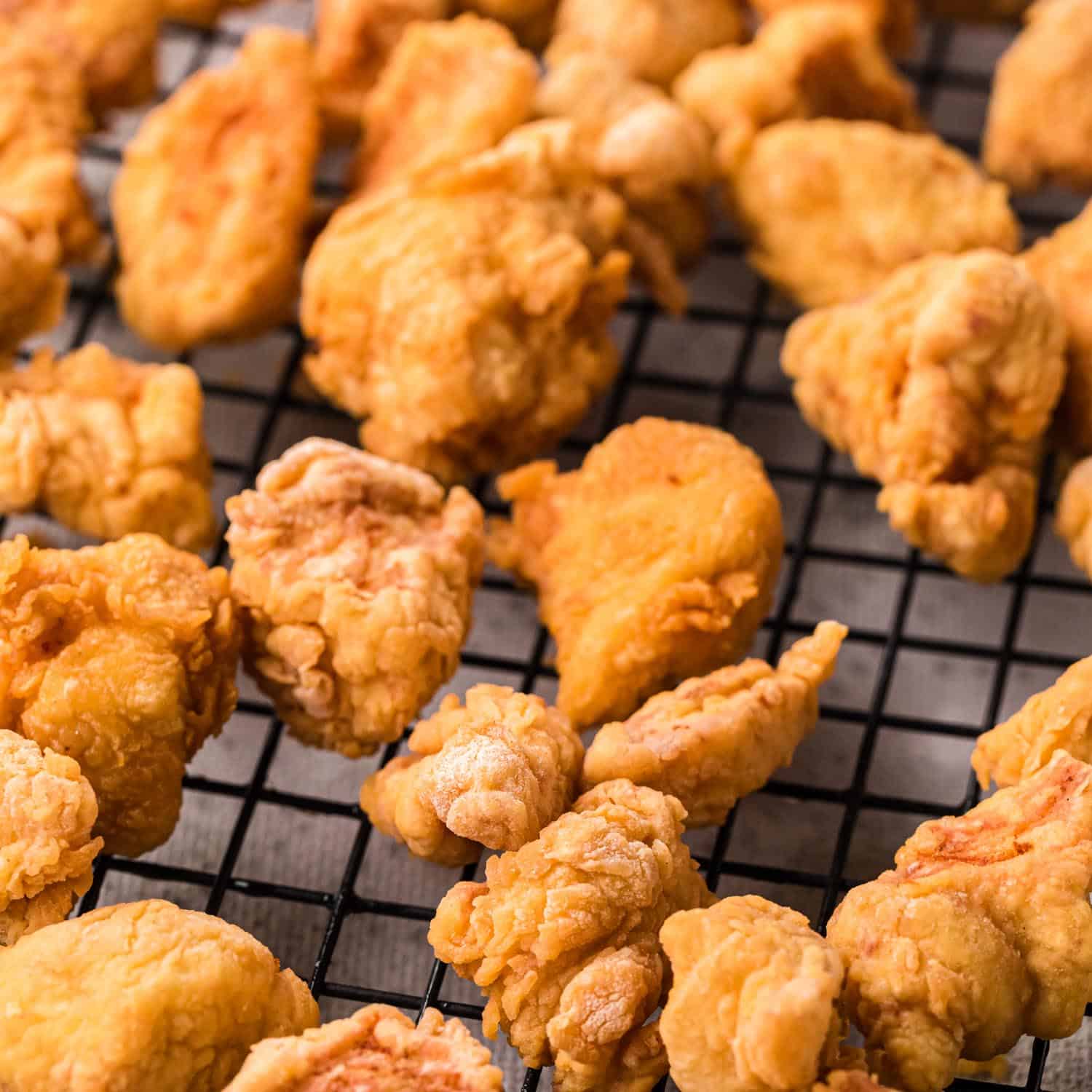 Crispy chicken pieces placed on a wire rack