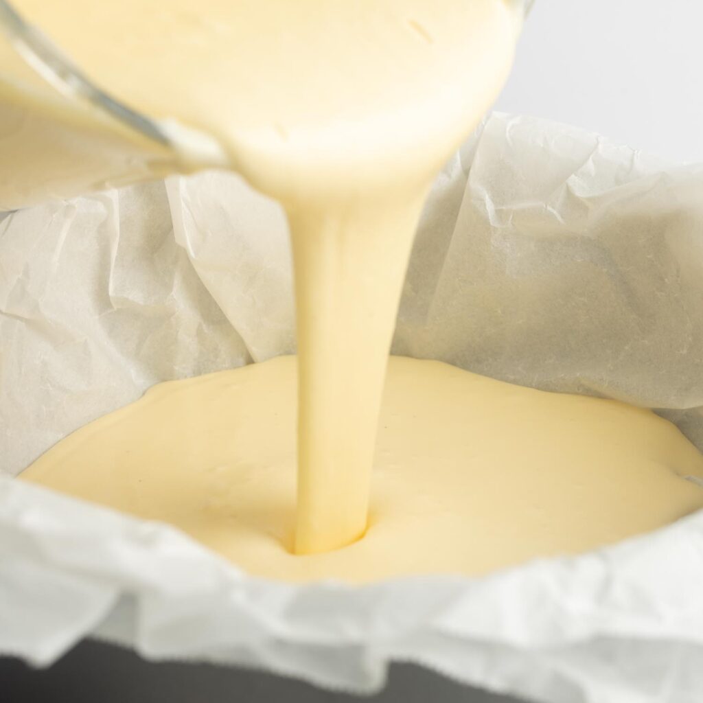 basque cheesecake batter poured into a pan lined with crumpled parchment paper.