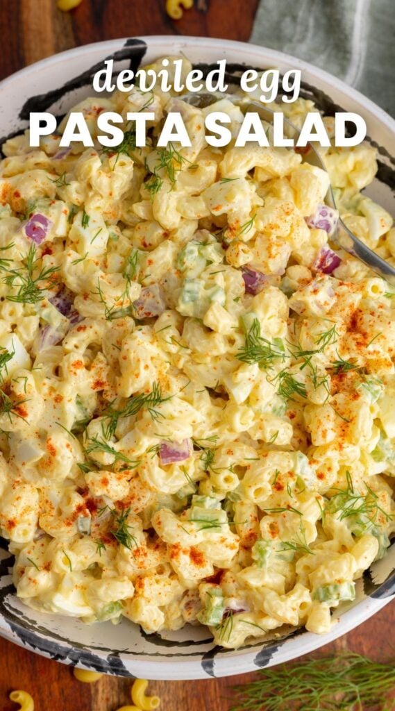 a bowl of pasta salad with dill sprigs on top. Text overlay says "deviled egg pasta salad"