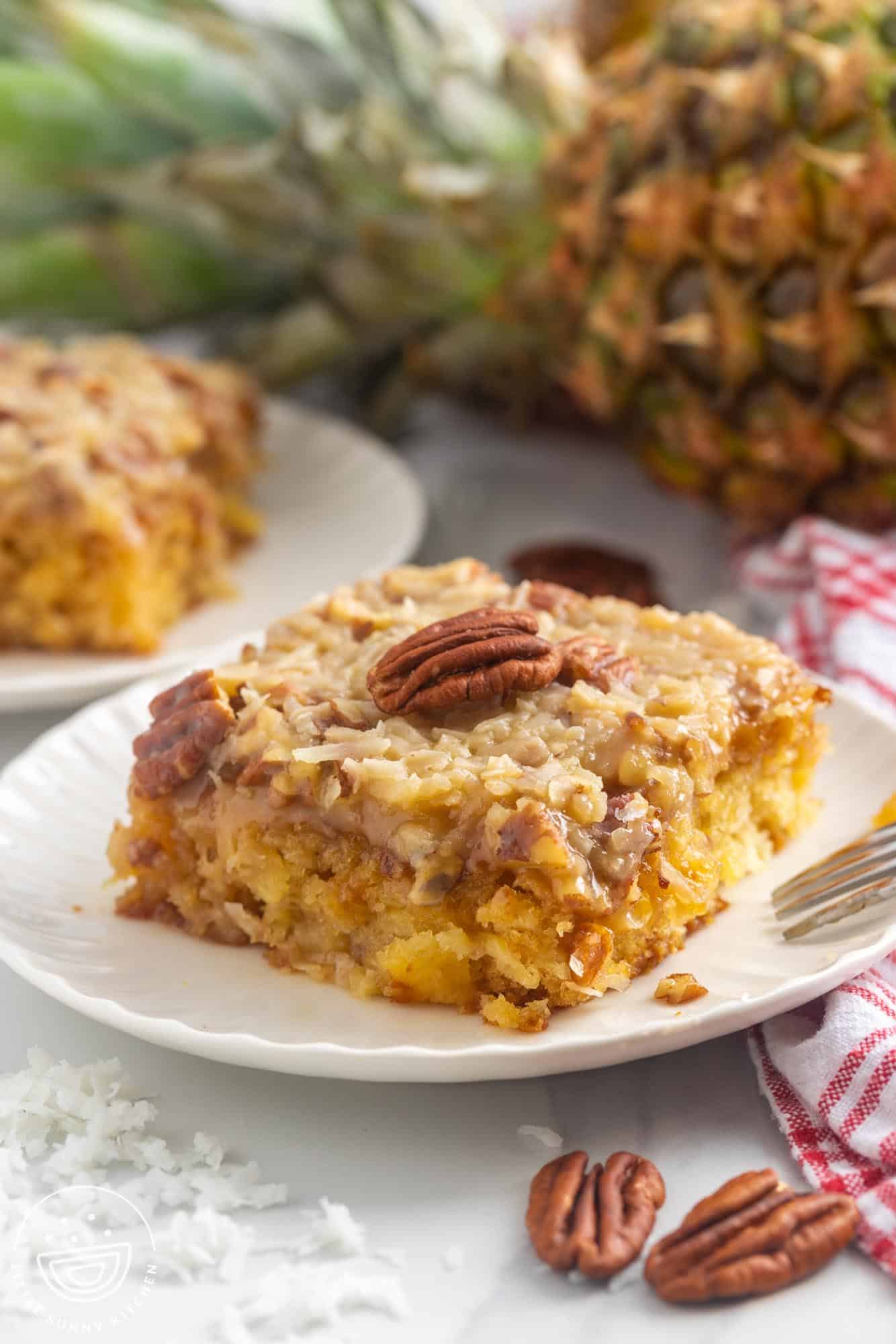 A slice of Do Nothing Cake on a small plate, topped with a pecan half.