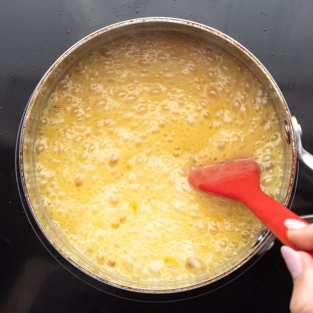 Butter, sugar, and evaporated milk, boiling in a saucepan.