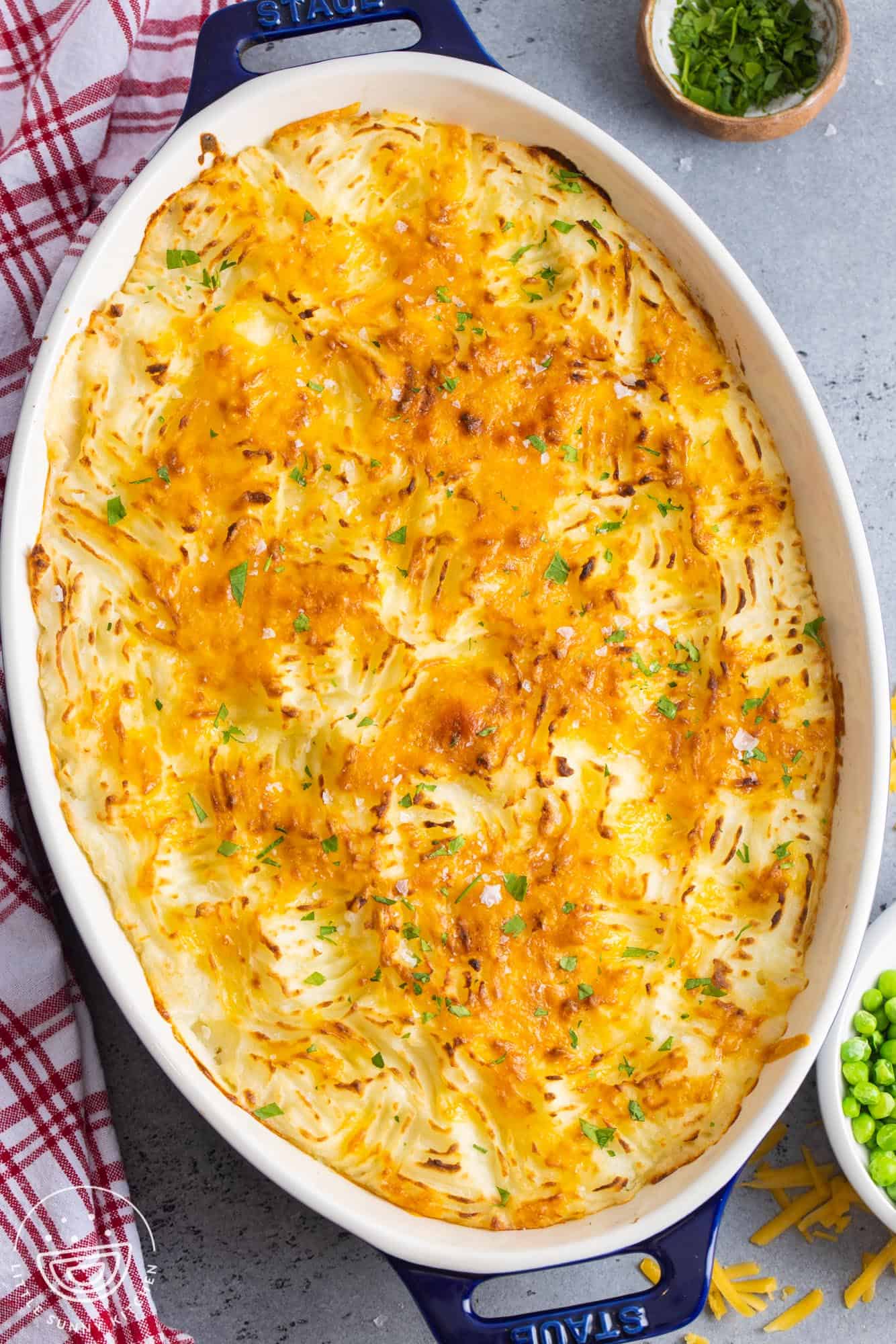 top down view of a potato topped fish stew pie in an oval baking dish.