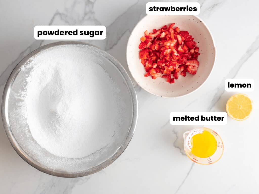 a bowl of powdered sugar next to diced strawberries, butter, and lemon juice in small bowls. 