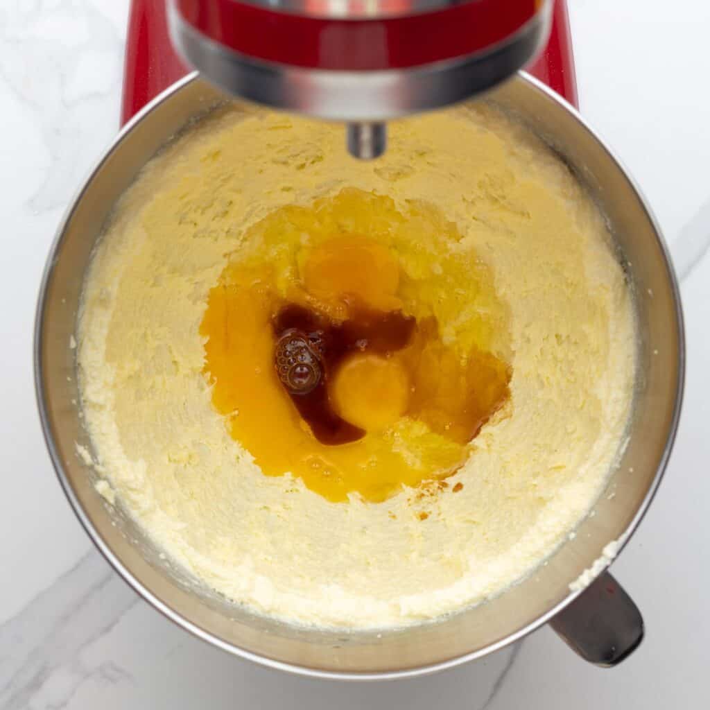 creamed butter and sugar in a KitchenAid stand mixer bowl. Eggs and vanilla are added.