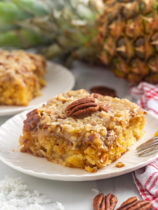 A slice of Do Nothing Cake on a small plate, topped with a pecan half.