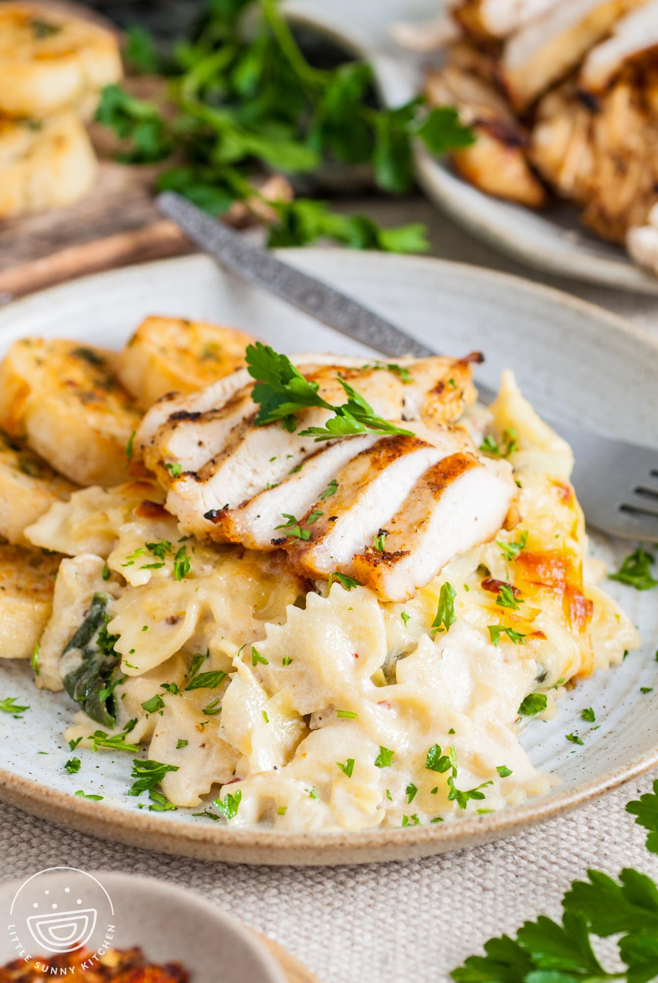 a dinner plate of pasta topped with chicken.