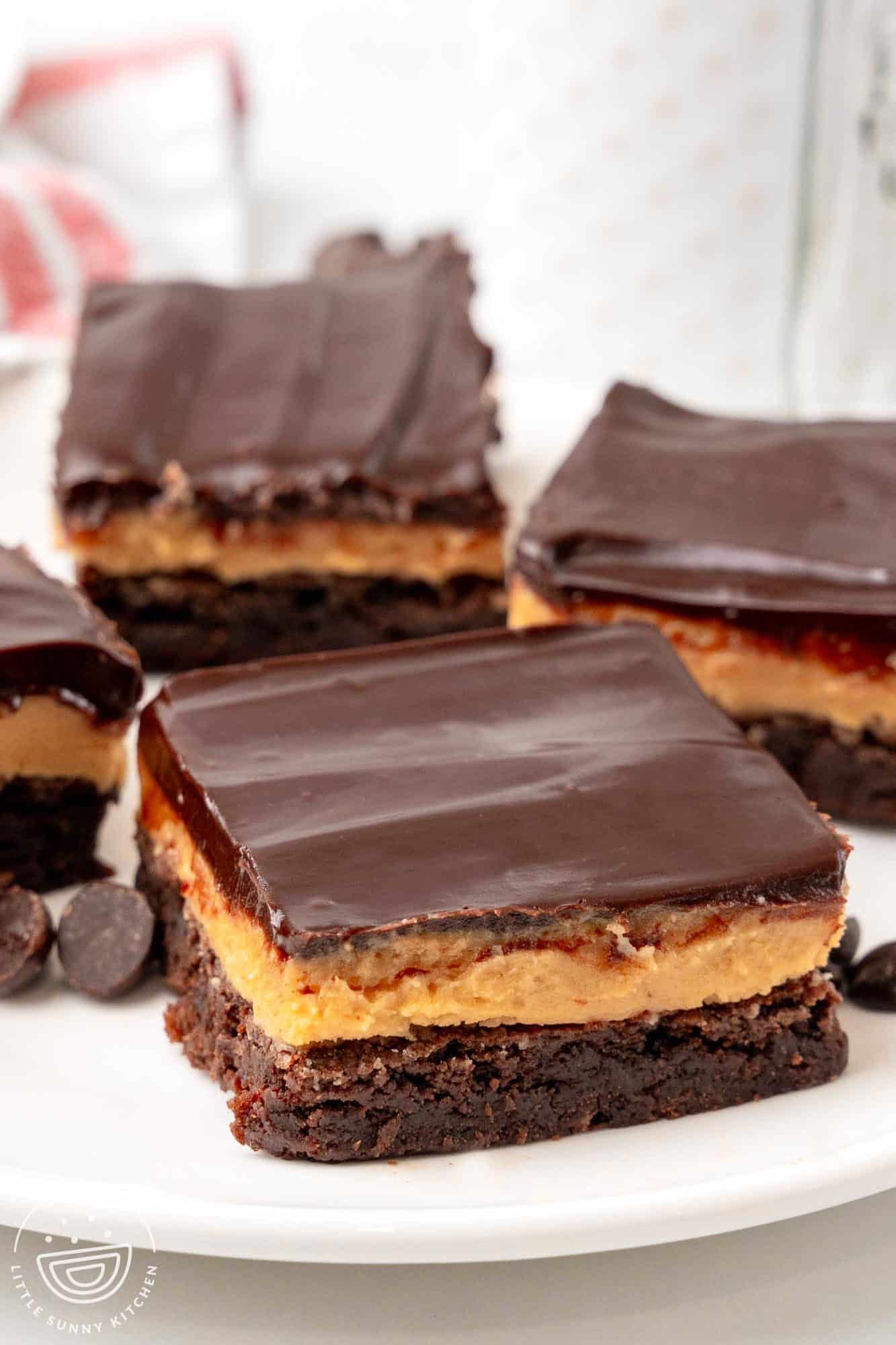 four square buckeye brownies on a white plate.