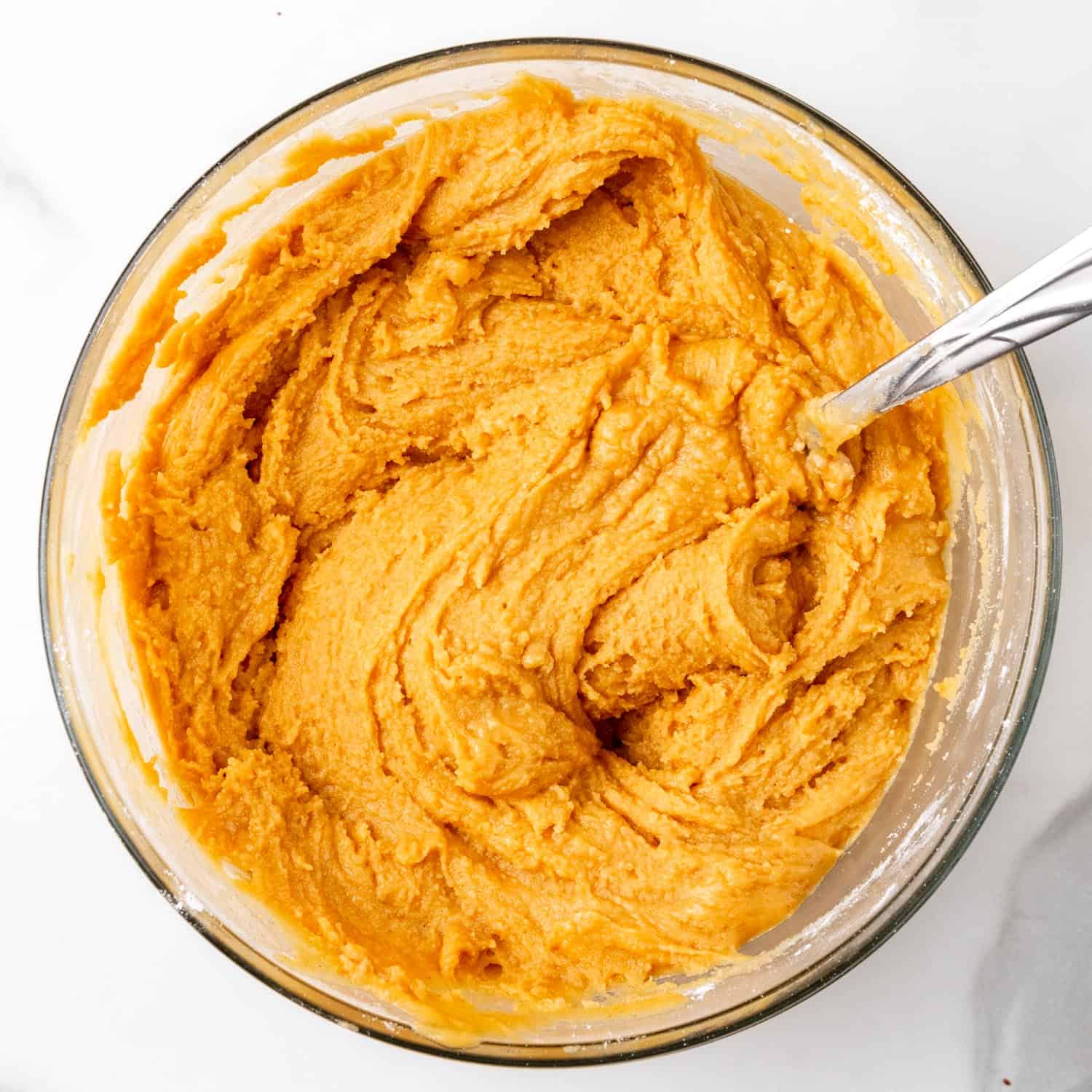 Peanut butter buckeye filling in a glass bowl with a spoon.