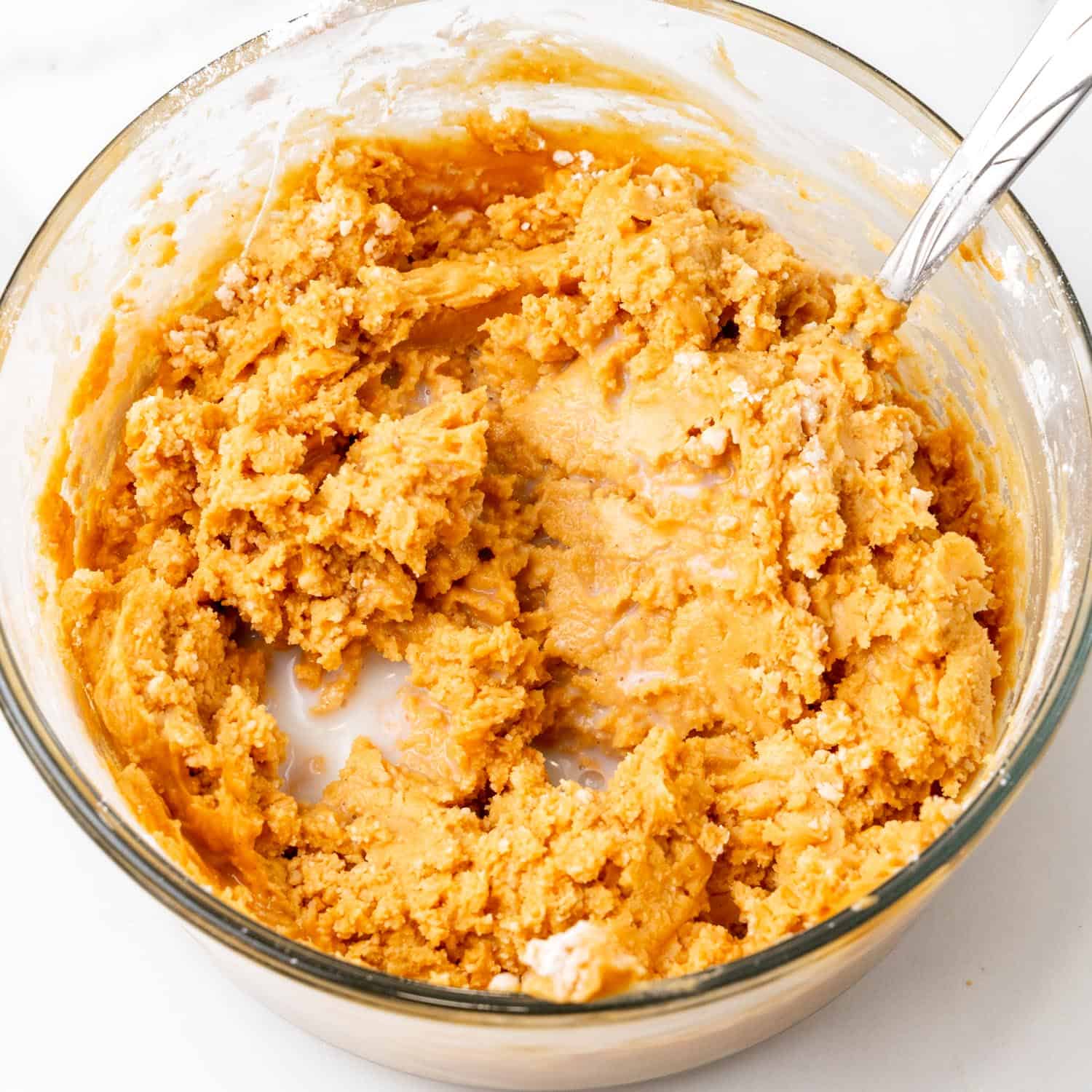 Peanut butter buckeye filling in a glass bowl with a spoon.