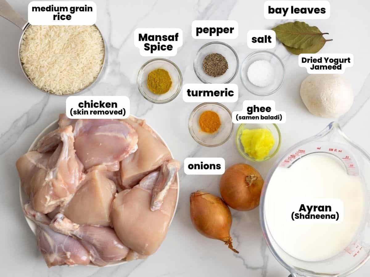 Ingredients needed to make chicken mansaf including chicken, rice, dried yogurt, ghee, onions, and spices.