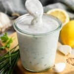 Homemade ranch dressing in a glass Weck jar, with a spoon showing the consistency
