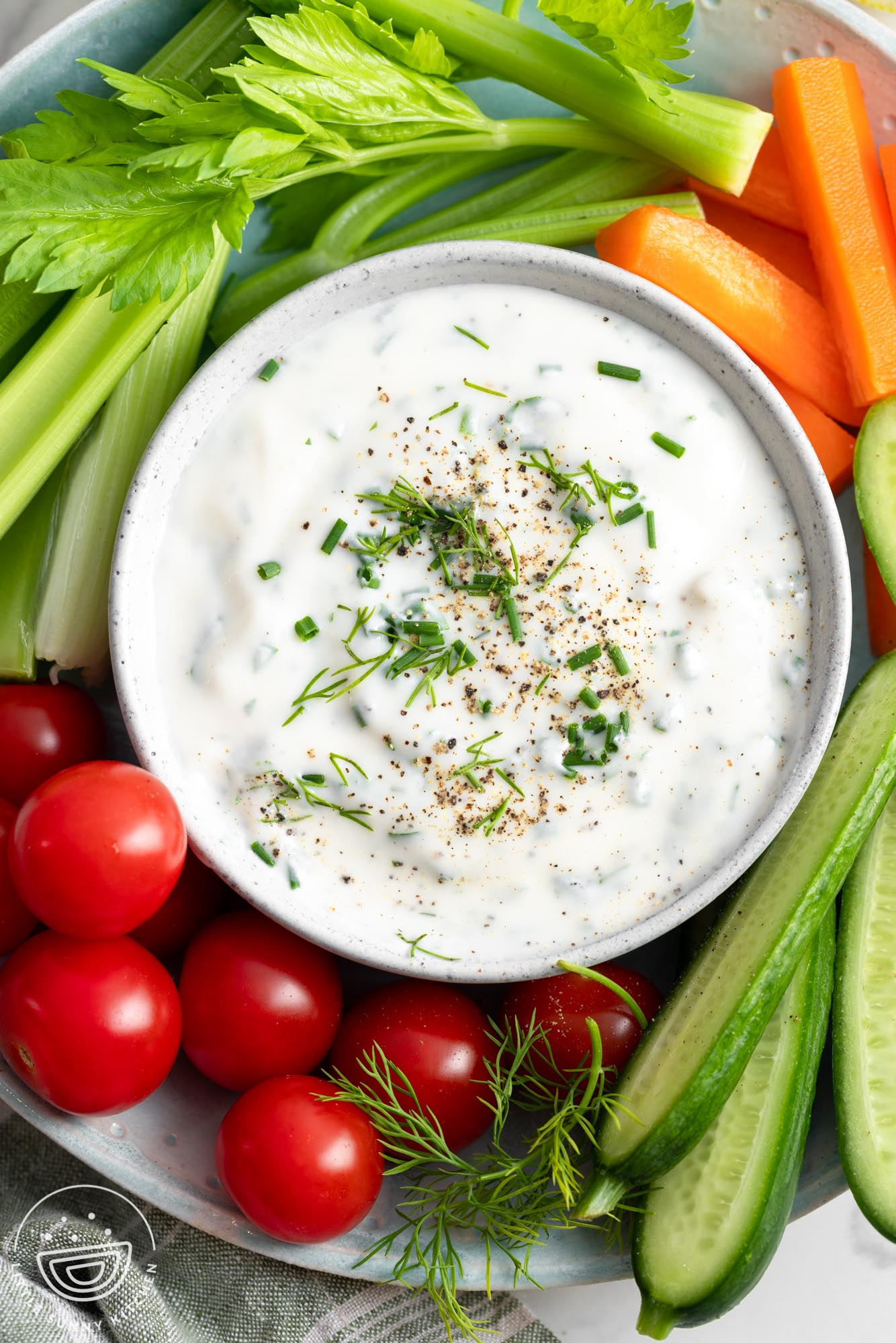 Overhead shot of ranch dressing in a small bowl, with fresh veggies on the side.