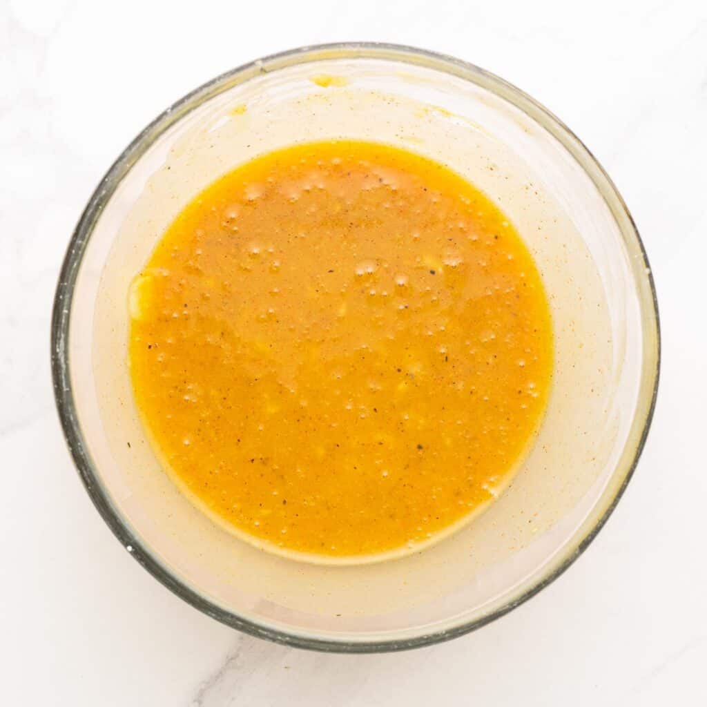 a glass bowl of honey mustard marinade.