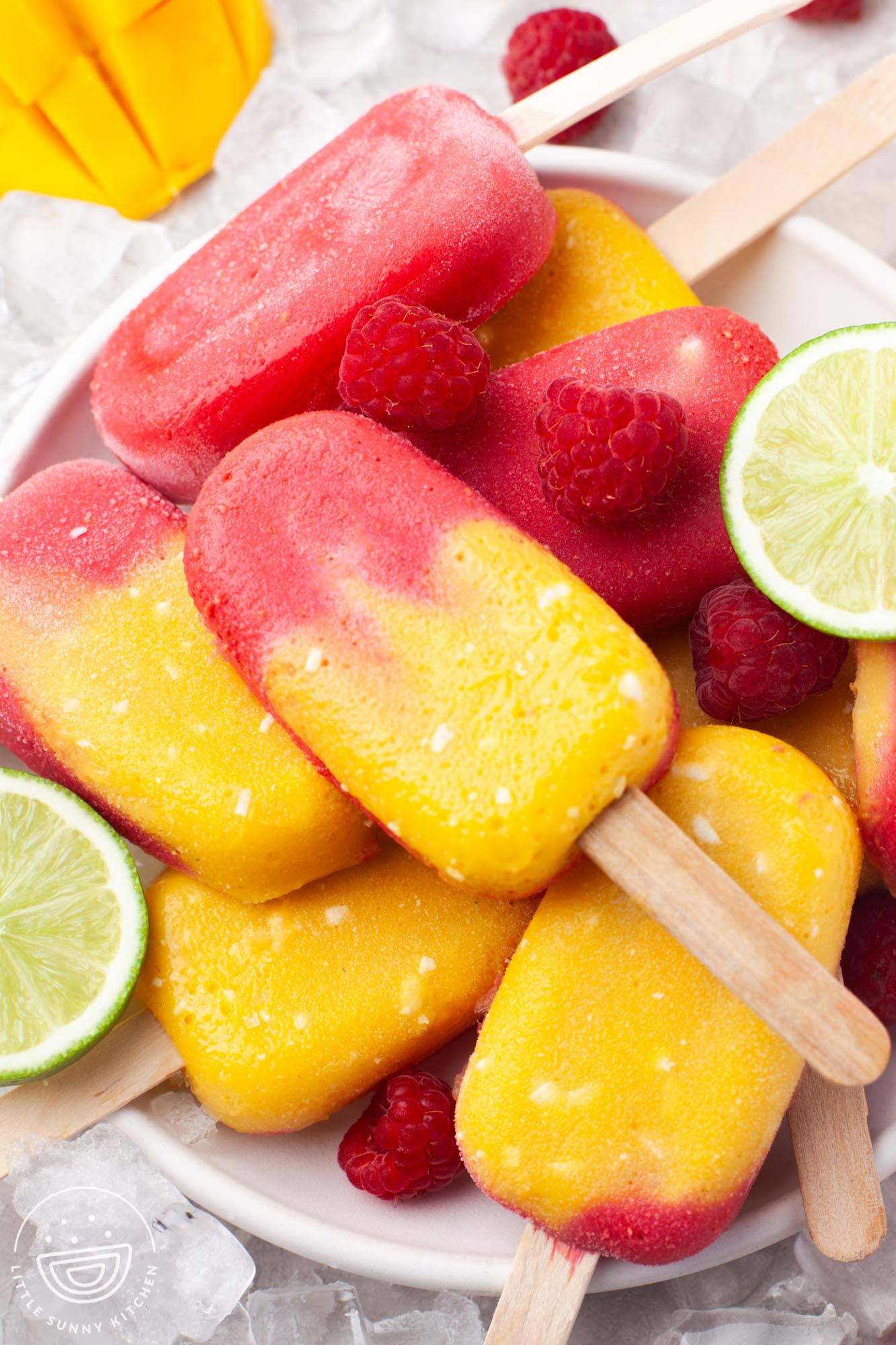 Close up shot of stacked mango raspberry popsicles on a white plate