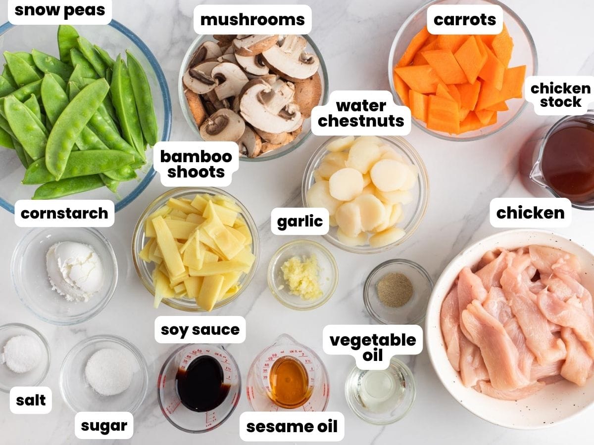 The ingredients needed to make moo goo gai pan at home, measured into small bowls on a marble counter.