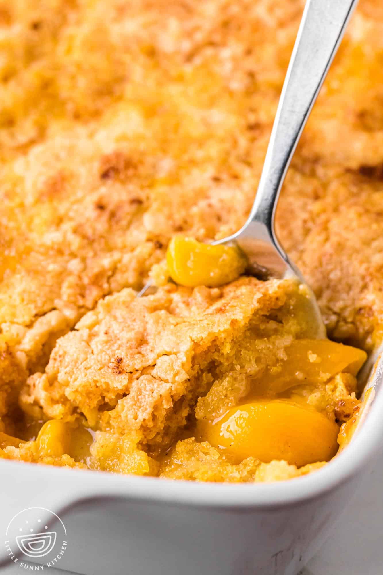 a spoon serving peach dump cake.