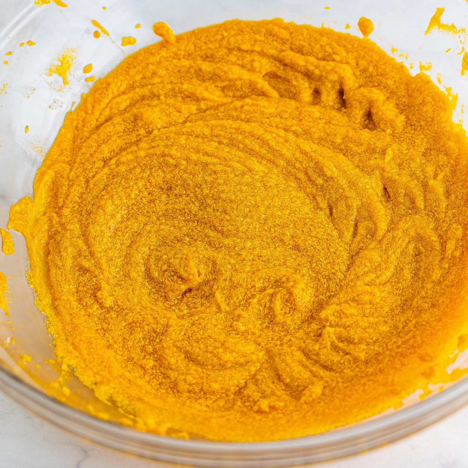 pumpkin puree mixed with eggs in a glass bowl.