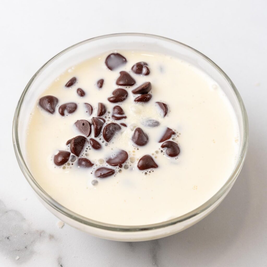 chocolate chips in a small bowl of hot milk.