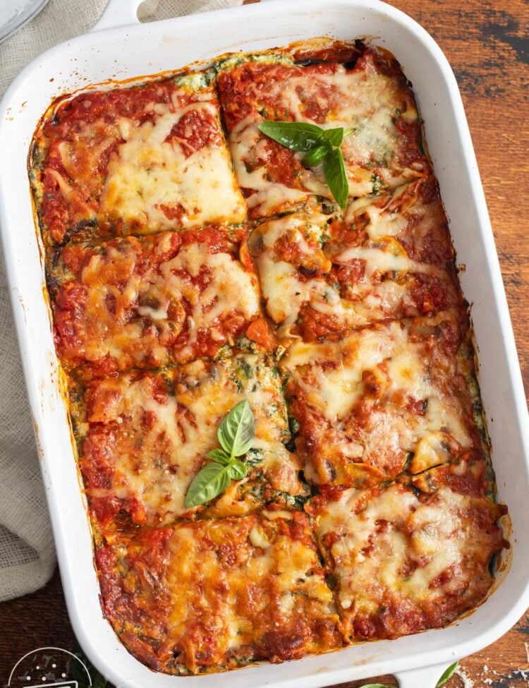 overhead view of homemade eggplant lasagna in a white ceramic baking dish, cut into 8 squares.