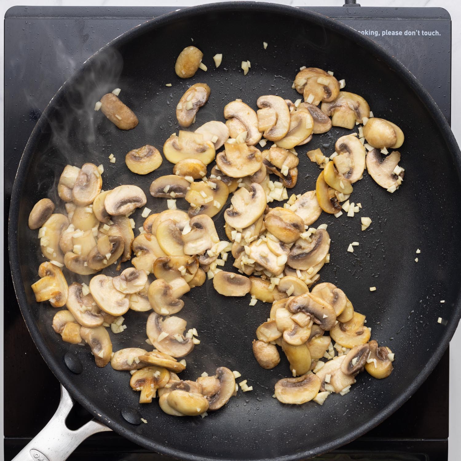 sliced button mushrooms and garlic in a nonstick pan.