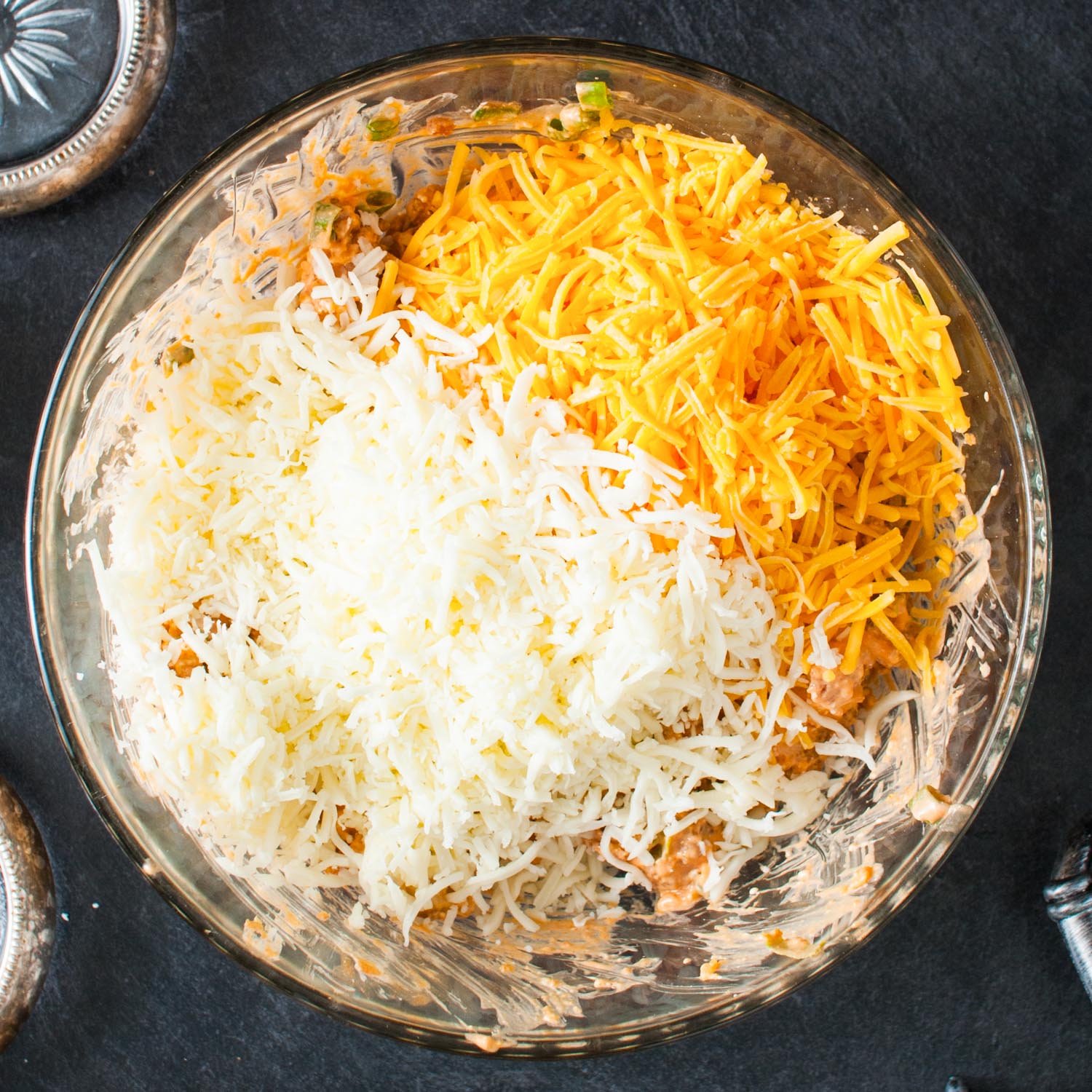 shredded cheddar and mozzarella cheese added to a bowl of creamy buffalo chicken.