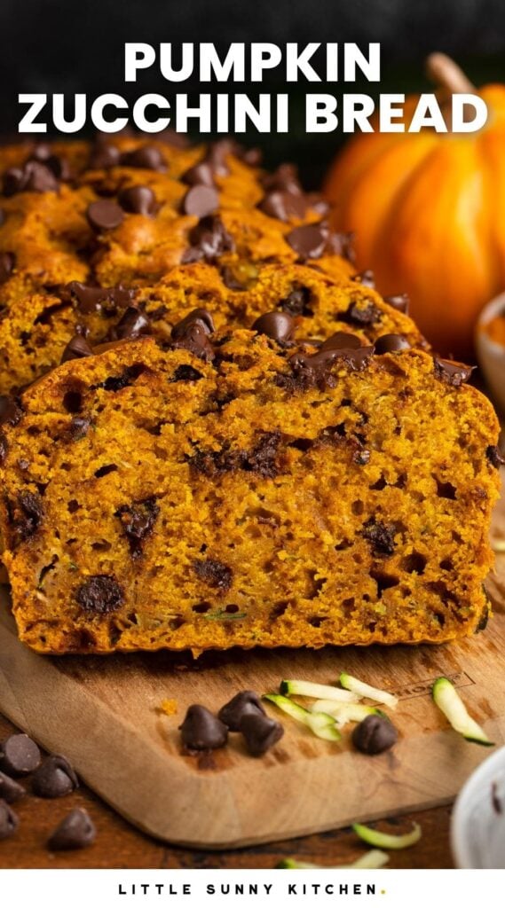 Sliced pumpkin zucchini bread with chocolate chips on a wooden cutting board. Text overlay says "pumpkin zucchini bread" in white letters.